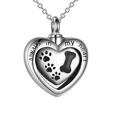 Delicate dog urn necklace, designed to hold a small portion of ashes, featuring a sleek, heart-shaped pendant with an engraved dog bone and paws silhouette, symbolizing love and remembrance."
